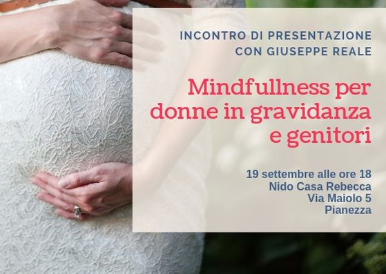 Madre accarezza pancione nel percorso mindfulness per donne in gravidanza e genitori